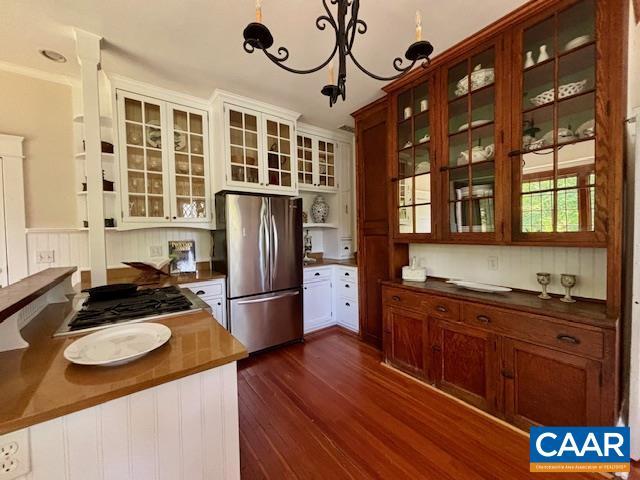 kitchen with glass insert cabinets, appliances with stainless steel finishes, dark countertops, and dark wood-style floors