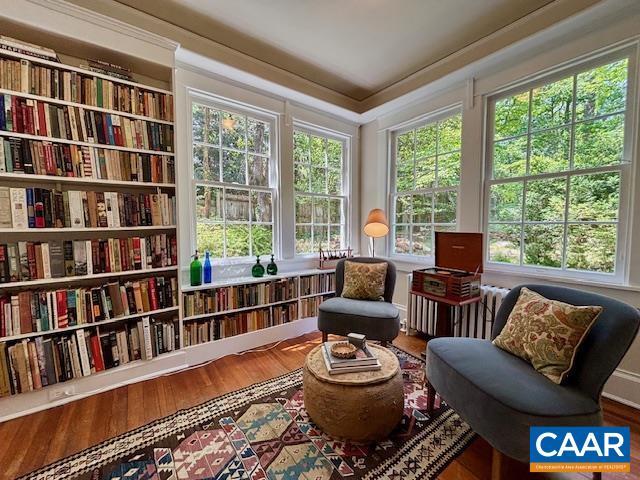 sitting room with radiator heating unit and wood finished floors