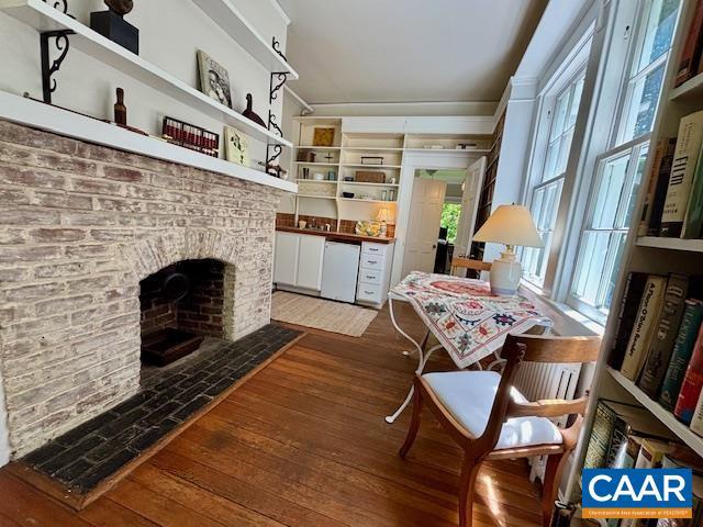 interior space with a brick fireplace and light wood-style flooring