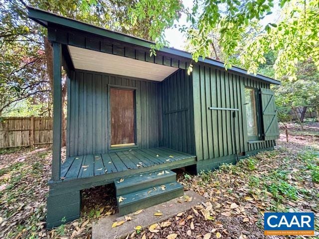 view of outbuilding with fence and an outbuilding