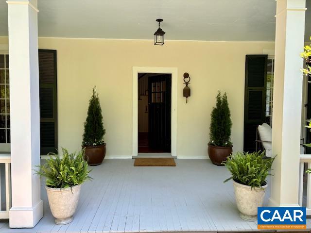 property entrance featuring covered porch and stucco siding