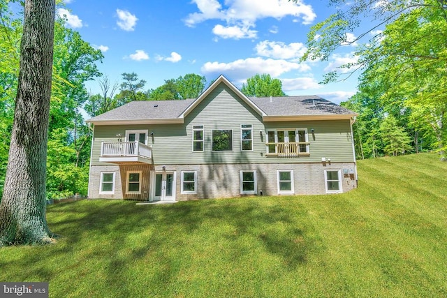 back of house with a balcony and a lawn