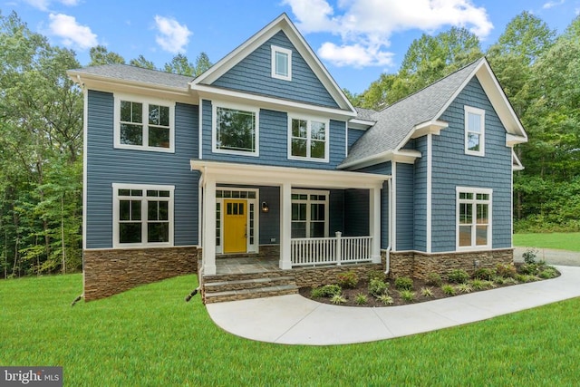 craftsman-style house featuring covered porch and a front yard