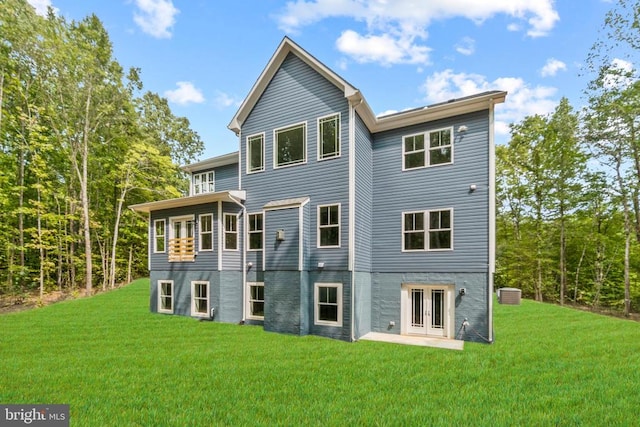 rear view of property with french doors and a lawn