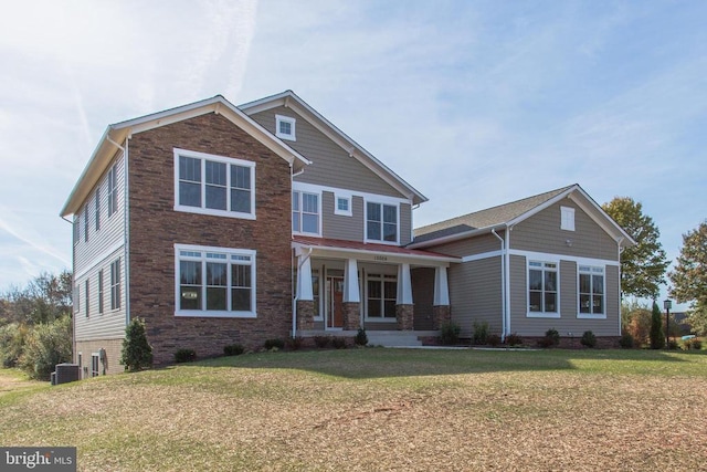 craftsman-style house featuring covered porch, central AC, and a front lawn