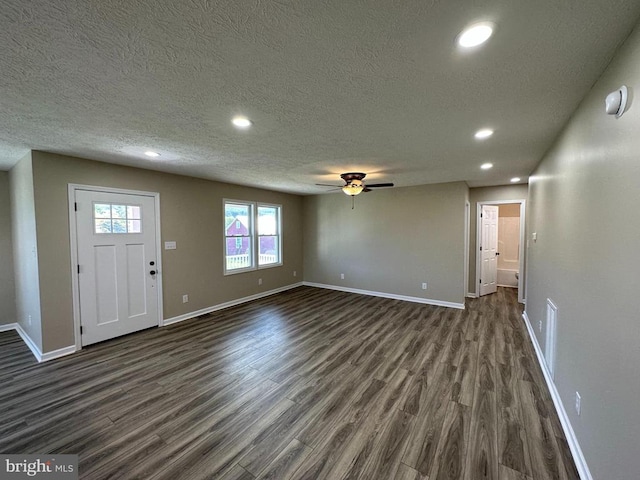 interior space with ceiling fan, a textured ceiling, and dark wood-type flooring