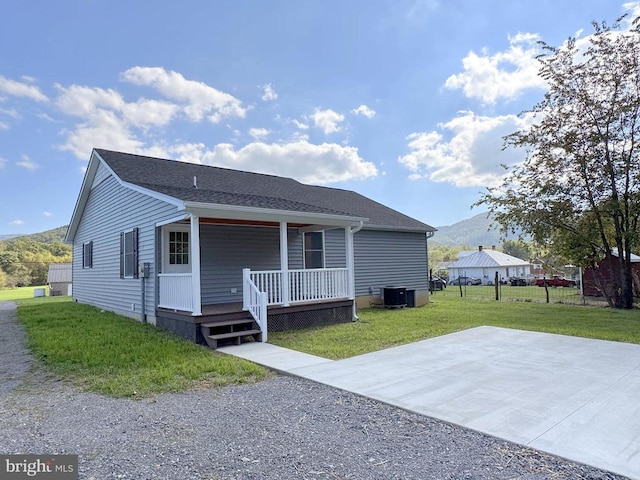 view of front of house with a porch, central AC unit, and a front yard