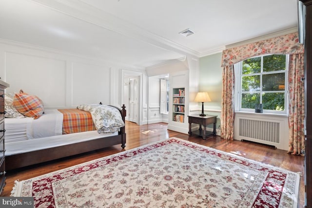 bedroom with crown molding, radiator, and dark wood-type flooring