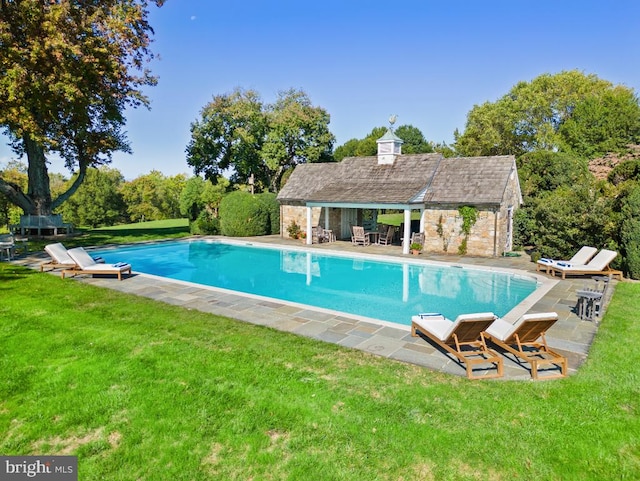 view of swimming pool featuring a yard and a patio