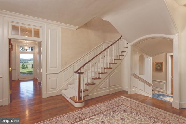 stairway with hardwood / wood-style floors and ornamental molding