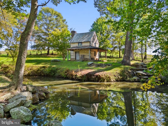 view of home's community with a water view and a yard