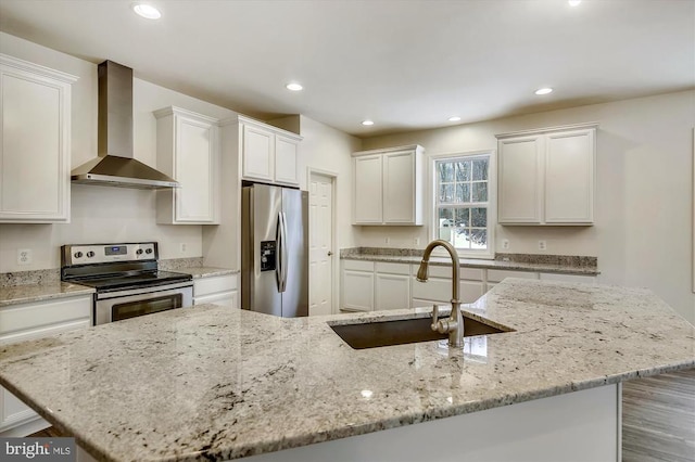 kitchen with sink, white cabinets, stainless steel appliances, light stone countertops, and wall chimney exhaust hood