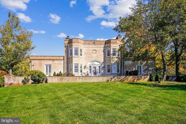 back of property with a lawn and french doors