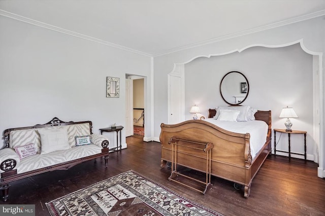 bedroom with ornamental molding and dark hardwood / wood-style floors