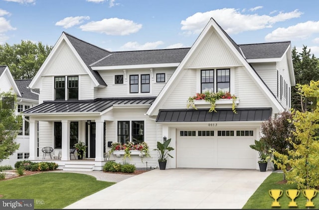 modern inspired farmhouse with a front yard, a porch, and a garage