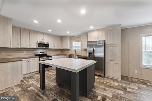 kitchen with backsplash, hardwood / wood-style floors, stainless steel appliances, and a kitchen island