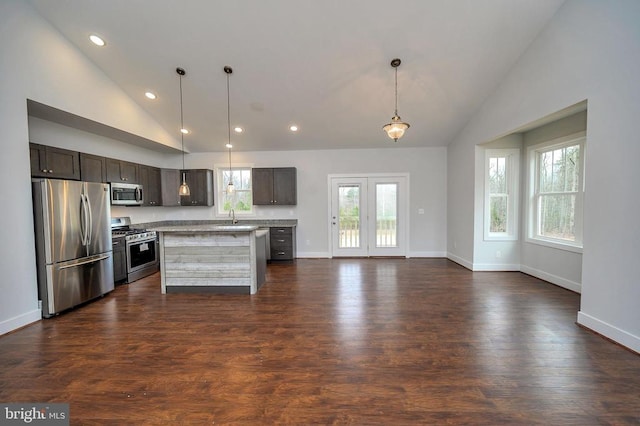 kitchen featuring a center island, pendant lighting, stainless steel appliances, and dark wood-type flooring