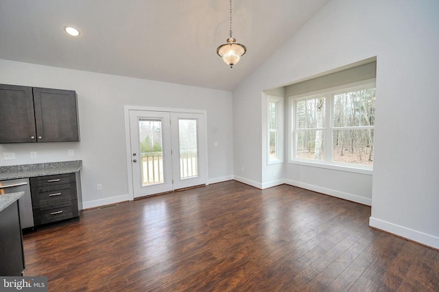 interior space featuring dishwasher, dark wood-type flooring, lofted ceiling, hanging light fixtures, and light stone countertops