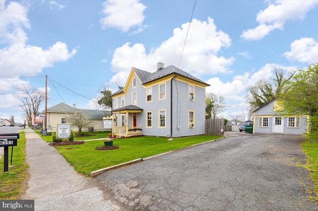 view of front of property with a front lawn and an outdoor structure