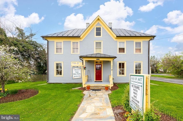 view of front of property featuring a front yard and solar panels