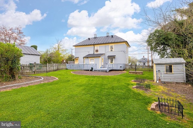 rear view of property with a lawn and a storage unit