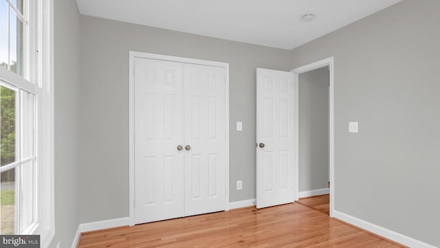 unfurnished bedroom featuring a closet and light hardwood / wood-style flooring