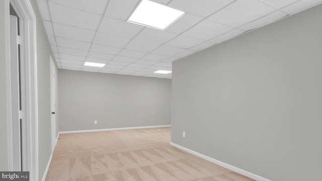 basement featuring light colored carpet and a drop ceiling