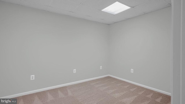 carpeted spare room with a paneled ceiling