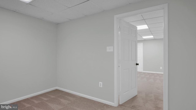 carpeted spare room with a drop ceiling