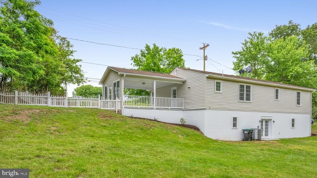 back of property featuring central AC and a lawn