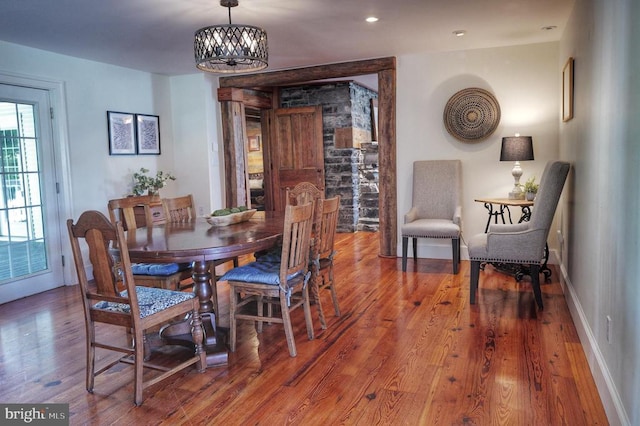 dining room with wood-type flooring and an inviting chandelier