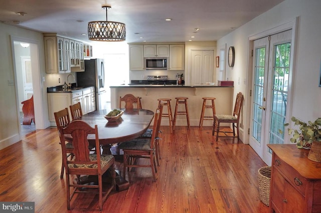 dining area with french doors, light wood-type flooring, and sink