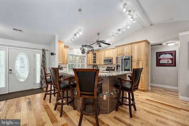 dining area with ceiling fan, light hardwood / wood-style flooring, and lofted ceiling with beams