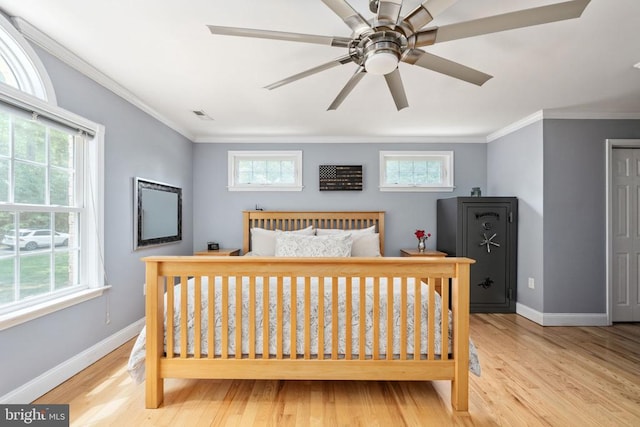 bedroom with ceiling fan, crown molding, and light hardwood / wood-style flooring