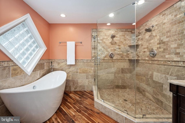 bathroom with vanity, hardwood / wood-style flooring, tile walls, and independent shower and bath