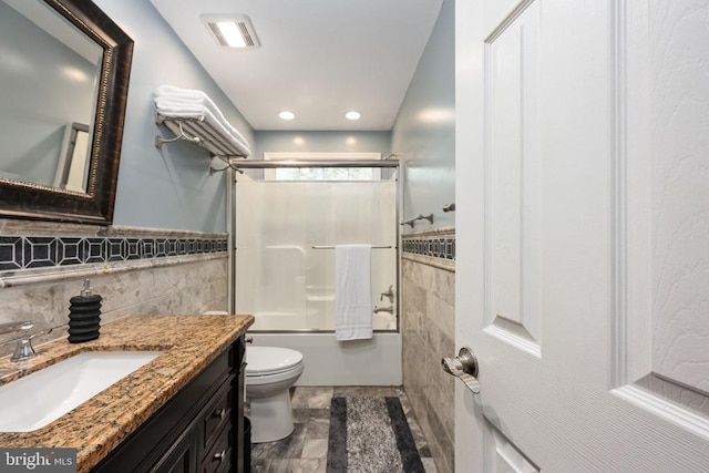 full bathroom featuring combined bath / shower with glass door, vanity, and toilet