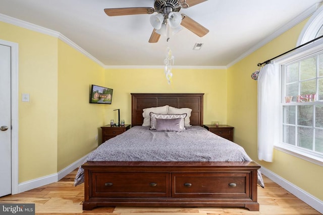 bedroom with light hardwood / wood-style floors, multiple windows, crown molding, and ceiling fan