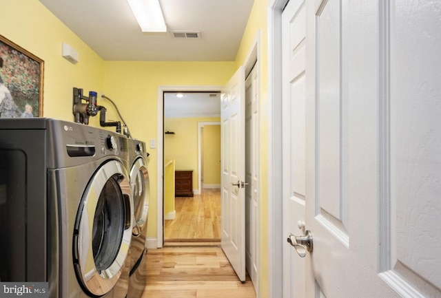 washroom with light wood-type flooring and separate washer and dryer