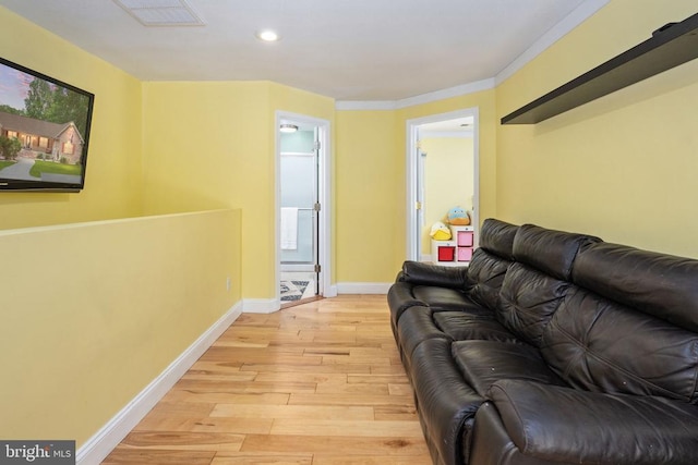 living room with light wood-type flooring and ornamental molding