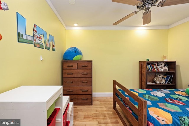 bedroom with light hardwood / wood-style floors, ceiling fan, and crown molding