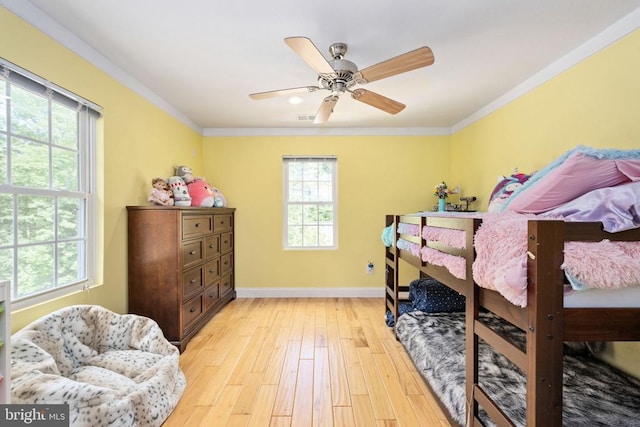 bedroom with ceiling fan, light hardwood / wood-style floors, and crown molding