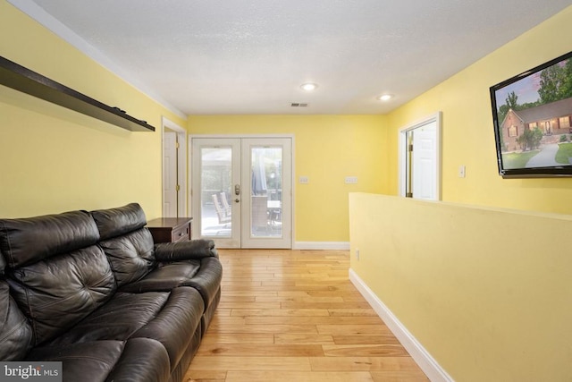 living room with french doors and light hardwood / wood-style flooring