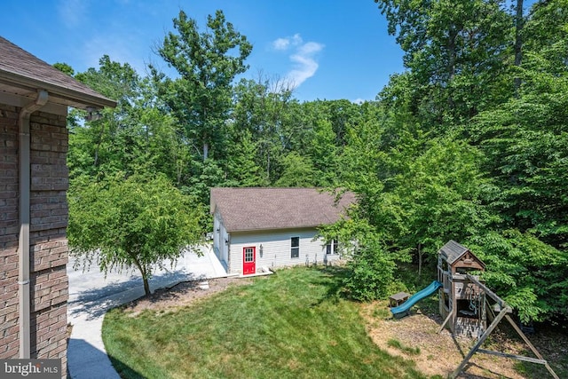 exterior space with a playground, a garage, an outdoor structure, and a yard