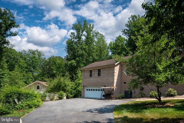 view of property exterior featuring a garage and central AC unit