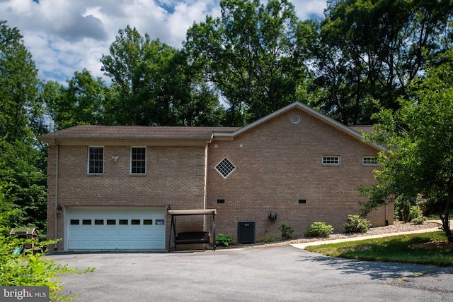 exterior space with a garage and cooling unit