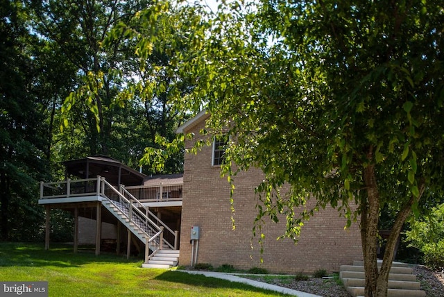 rear view of house with a lawn and a wooden deck