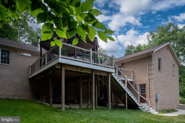 rear view of property with a lawn and a deck