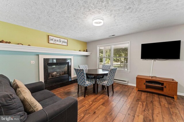 interior space with a premium fireplace, a textured ceiling, and hardwood / wood-style flooring