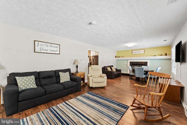 living room with a textured ceiling and wood-type flooring