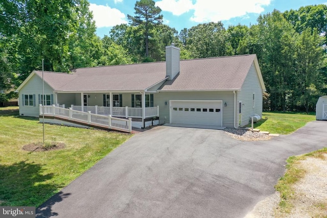 view of front facade with covered porch, a garage, and a front lawn